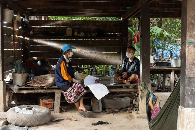 A health worker sits with a local farmer